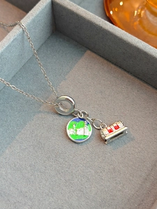Détail du collier en titane argenté avec pendentifs en émail coloré sur plateau en velours