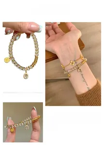 Detail of white crystal bead bracelet with gold pendants and layered floral chain
