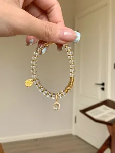 Macro detail of clear crystal beads bracelet with gold accents and sparkling oval charm