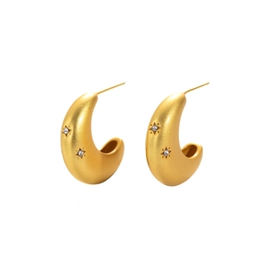 Minimalist matte gold crescent earrings with engraved star patterns and CZ stones