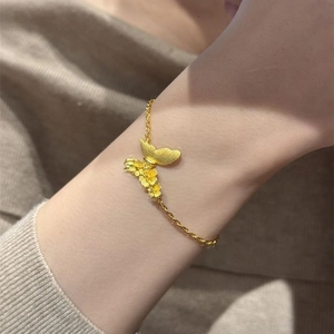 Elegant gold brushed butterfly and floral bracelet featuring delicate nature-inspired charms