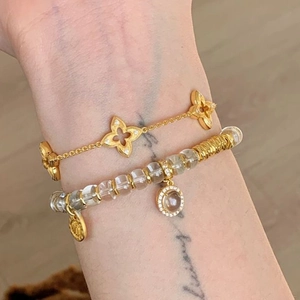Luxury layered gold chain bracelet with white crystal beads and clover floral charms