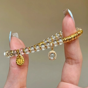 White crystal beaded bracelet with gold 'Shun' charm and sparkling oval pendant