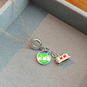 Collier en argent avec pendentif en émail et breloque édifice dans un écrin de velours