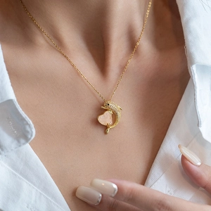 Elegant dolphin heart pendant necklace with pink crystal and zircon pavé on a model