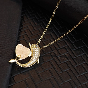 Elegant gold dolphin necklace with sparkling zircon heart pendant on a premium display