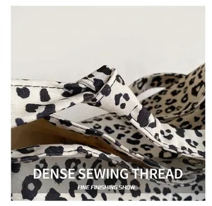 Detail view of reinforced stitching on leopard print tote bag straps and edges
