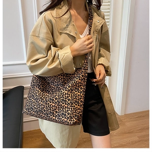Fashionable large leopard print tote bag styled with a khaki trench coat for daily commuting
