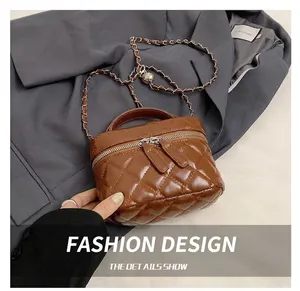 Detail showing the brown quilted leather mini bag with chain strap on a grey blazer