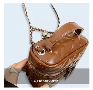 Close-up of brown quilted faux leather vanity bag with chain strap and top handle