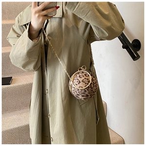 Detail of spherical leopard print plush bag with gold ring handle and metal chain