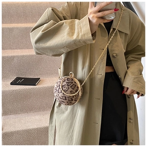Close-up of leopard print spherical hard shell bag with golden metal ring and chain