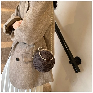 Detail of spherical leopard print evening bag with diamond-set gold handle and chain