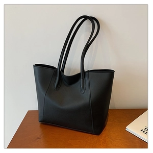 Close-up of the leaf-shaped stitching and durable handle on this black tote bag