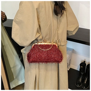 Detail of red sequined shell bag featuring a vintage gold metal frame and chain strap
