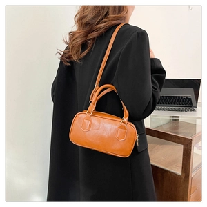 Sac bowling rétro caramel avec bandoulière réglable présenté dans une scène quotidienne