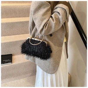 Detail of vintage black feather texture shell bag with golden metal frame and chain