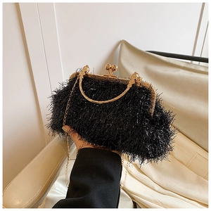 Close-up of elegant black tassel evening clutch bag with gold kissing lock and chain strap
