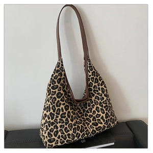 Detail of leopard print tote bag with durable canvas texture and leather shoulder strap