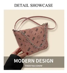 Détail du sac bandoulière rose avec motif ours, texture grainée et chaîne argentée