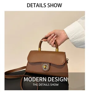 Detailaufnahme der braunen Tasche mit Wellenklappe und goldenem Drehverschluss