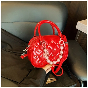 Detail of red quilted patent leather bag with sparkling rhinestones and beaded chain