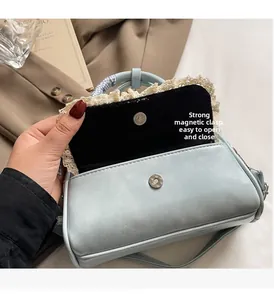 Close-up of light blue leather bag showing the magnetic buckle and lace edge detail