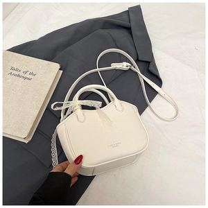 Detail of white lychee-patterned handbag with lace ribbon bow and thin shoulder strap