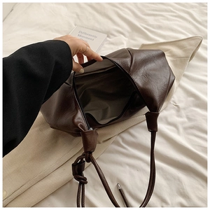 Detail of spacious dark brown soft leather hobo bag with zipper opening and lining