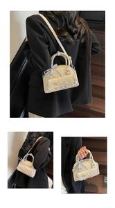 Detail of beige bowling bag with lace trim, bow, and blue checkered ribbon handle wrap