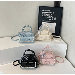 Detail view of four colorful mini Boston bags with bows and lace trim on steps