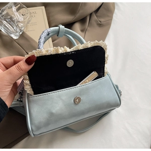 Detail of light blue crossbody bag with lace trim showing magnetic closure and interior space