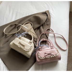 Close-up of cute PU leather handbags with elegant bows, lace trim and ribbon handles