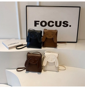 Detail view of mini rabbit crossbody phone bags in four colors on minimalist steps
