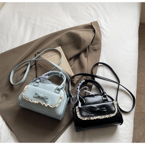 Detail of small square bags with lace edges, ribbon handles and cute bow decoration