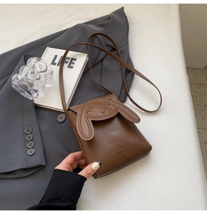 Detail view of brown PU leather crossbody bag featuring unique long-eared rabbit design
