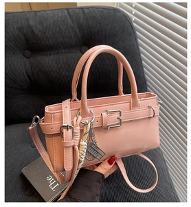Bolso bandolera de cuero rosa con colgante de tenis y hebillas plateadas finas
