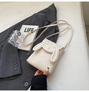 Detail of white mini crossbody bag featuring 3D rabbit ears and star embroidery details