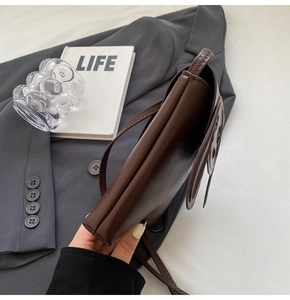 Detail of dark brown leather crossbody bag featuring a cute 3D bear design on the flap