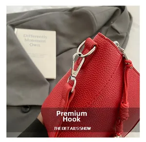 Detail of red lychee grain leather crossbody bag featuring high-quality silver metal hook