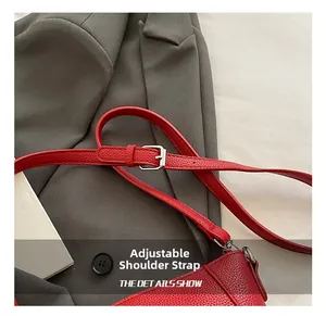 Detail view of red lychee grain leather bucket bag featuring adjustable silver buckle strap