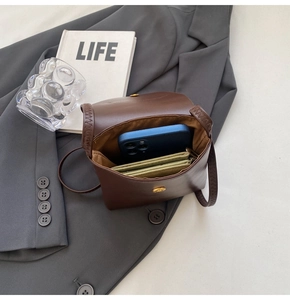 Brown leather crossbody bag interior showing space for a smartphone and wallet