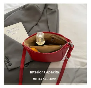 Detail showing the internal capacity and inner pocket of this red leather crossbody bucket bag