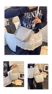 Detail of silver textured leather bucket bag with adjustable strap and embossed lettering