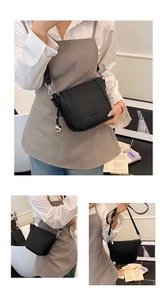 Detail of black pebbled leather bucket bag with silver hardware and adjustable strap