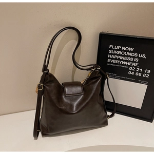 Détail du sac hobo en cuir marron foncé avec boucle dorée vintage et fermeture magnétique