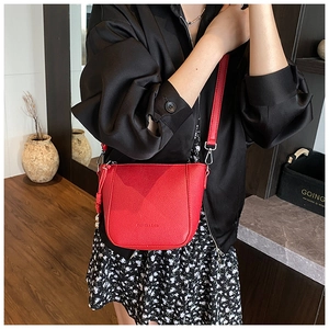 Close-up of a red litchi leather bucket bag featuring silver hardware and a debossed logo