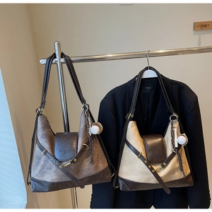 Détail de sacs cabas vintage en toile grise et beige avec garniture en cuir brun et breloques
