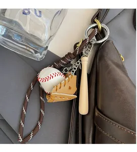 Détail d'un porte-clés mini gant et batte de baseball sur un sac à main en cuir marron