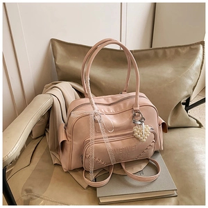 Borsa rosa in ecopelle con fiocco in pizzo, ciondolo a cuore perlato e bordi intrecciati